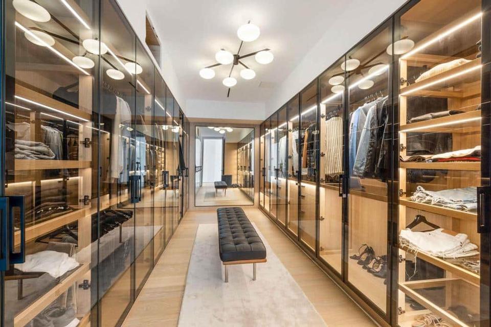 Walk-in dressing room with lit glass wardrobes