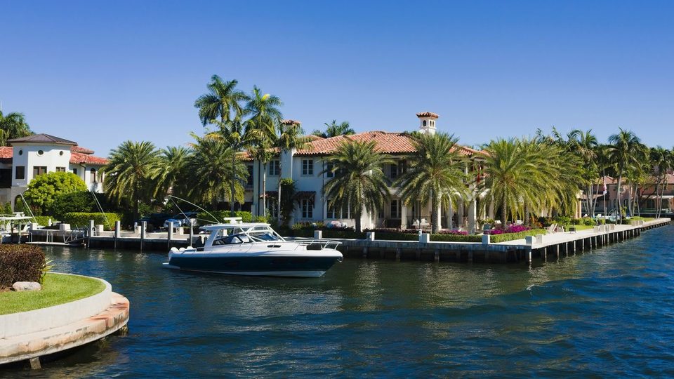 Waterfront homes with palm trees and a motor yacht on a Fort Lauderdale canal