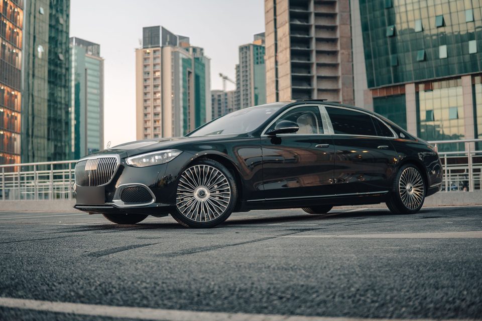 Black Mercedes-Maybach S-Class parked among glass towers, ready for a chauffeured ride in Miami