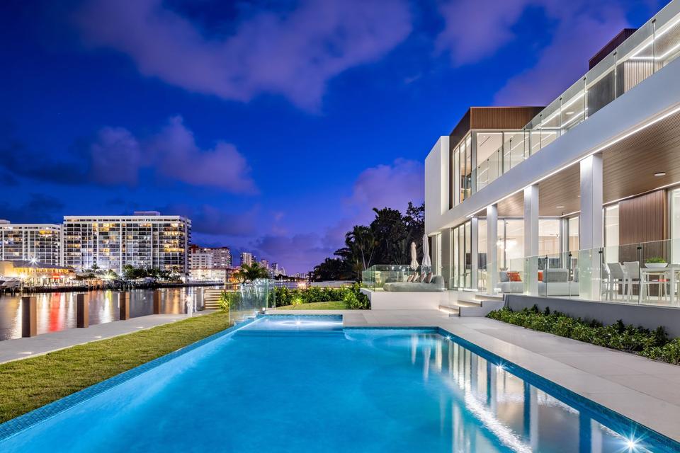 Villa Golden lap pool and lit terraces at twilight, Golden Isles, Hallandale Beach luxury rental