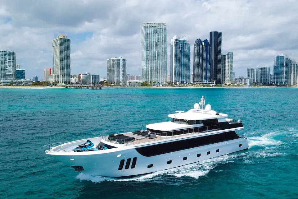 WHS 112 yacht cruising along the Miami coastline with towers behind