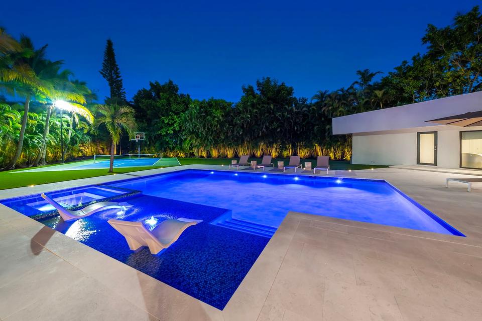 Villa Palma pool with sun shelf lit at dusk, Miami luxury rental