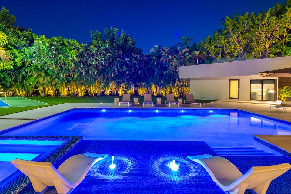 Villa Palma pool with lit fountains at night, Miami luxury rental