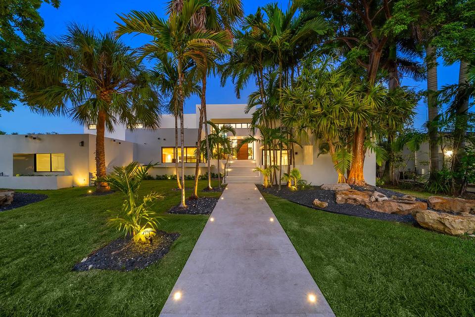 Villa Palma lighted garden walkway to the entrance at dusk, Miami luxury rental