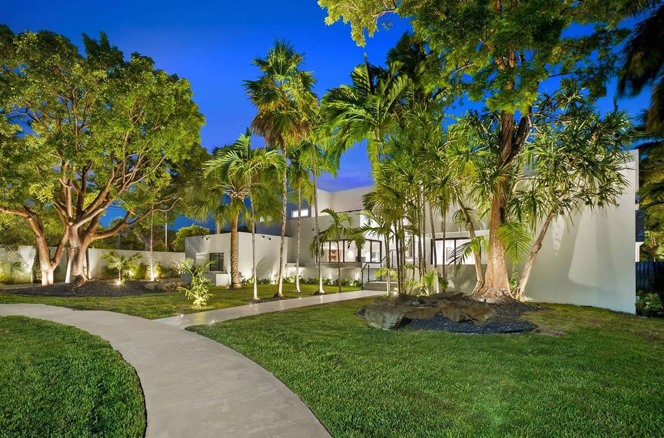 Villa Palma landscaped front garden with mature trees at dusk, Miami luxury rental