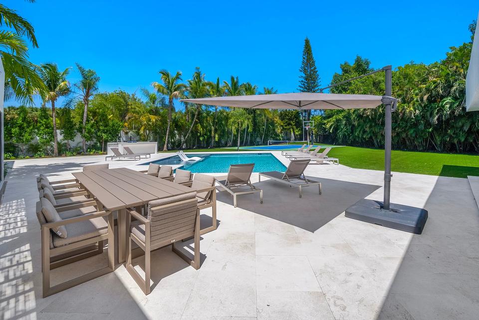 Villa Palma poolside dining table under a pergola, Miami luxury rental