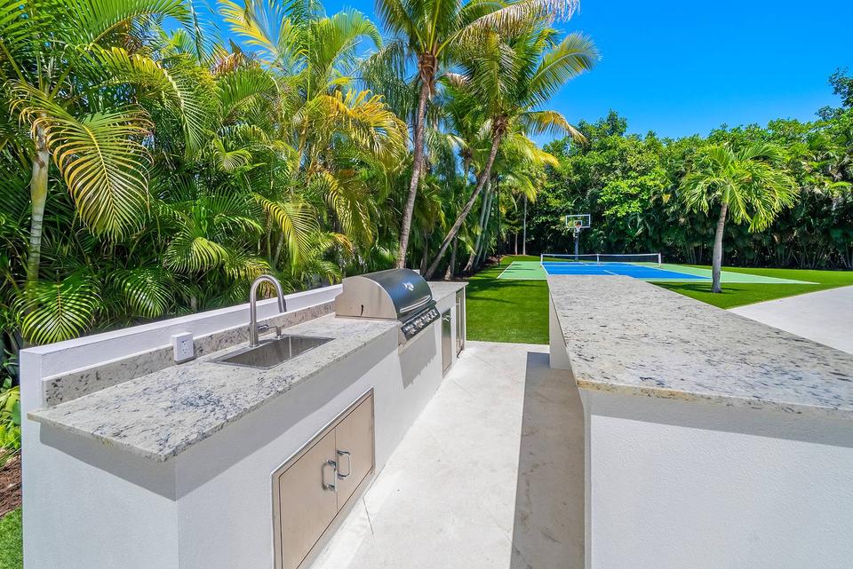 Villa Palma outdoor kitchen with grill overlooking the lawn, Miami luxury rental