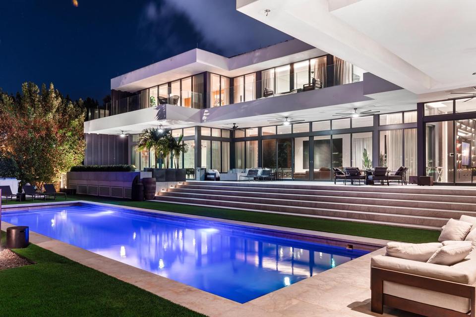 Villa Lavoro pool and three-storey modern villa lit at night, Miami Beach luxury rental