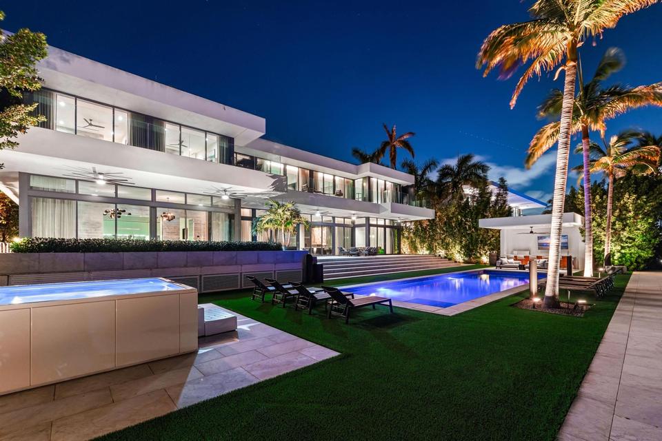Villa Lavoro glass facade and pool terrace at dusk, Miami Beach luxury rental