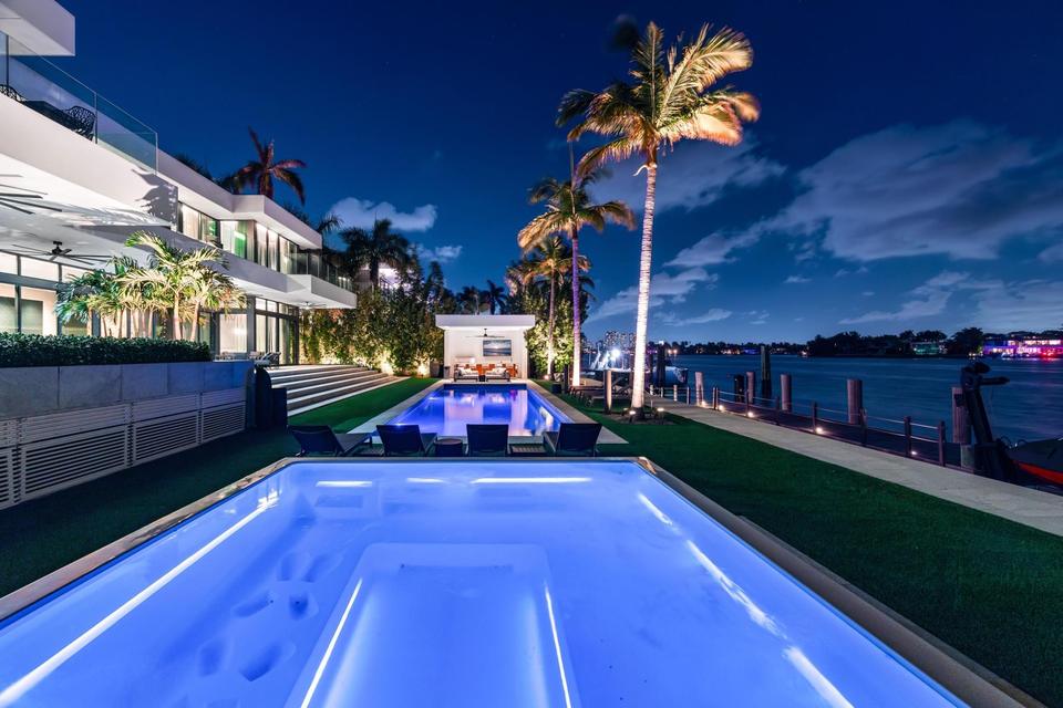 Illuminated lap pool and lawn at Villa Lavoro, Miami Beach luxury rental