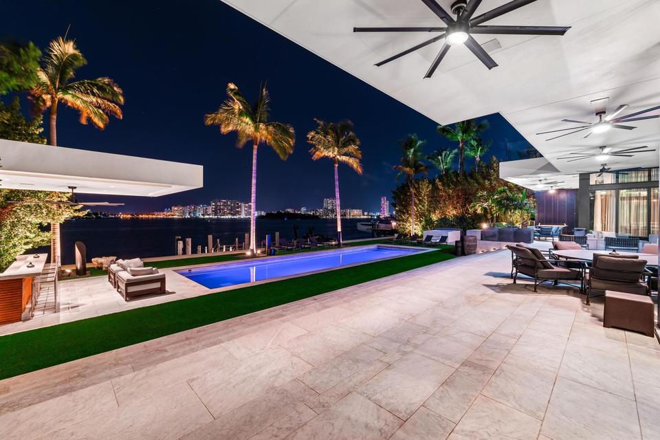 Covered terrace looking over the lap pool to the water, Villa Lavoro, Miami Beach luxury rental