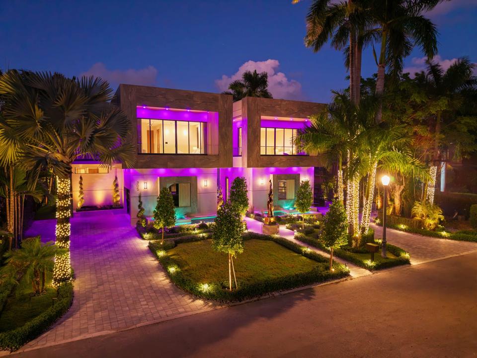 Villa Alpha facade and front garden lit at dusk