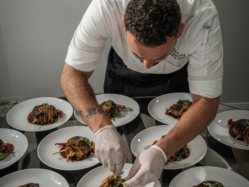 Private chef plating dishes seen from above
