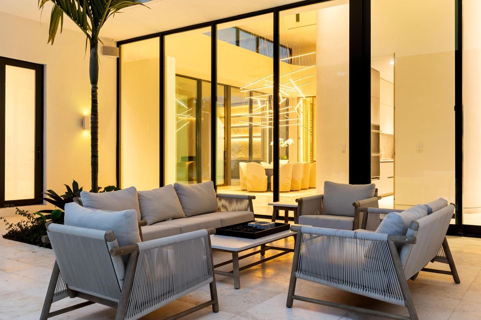 Covered outdoor lounge with glass walls lit at night, Villa Verano, Southwest Ranches
