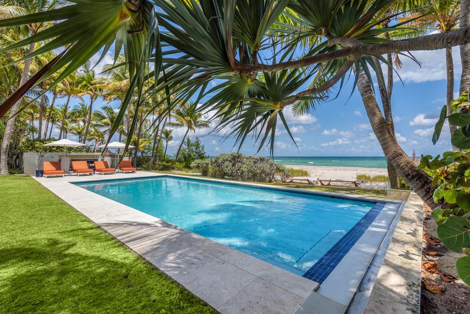Pool framed by palms with the ocean behind, Villa Ocean, Miami