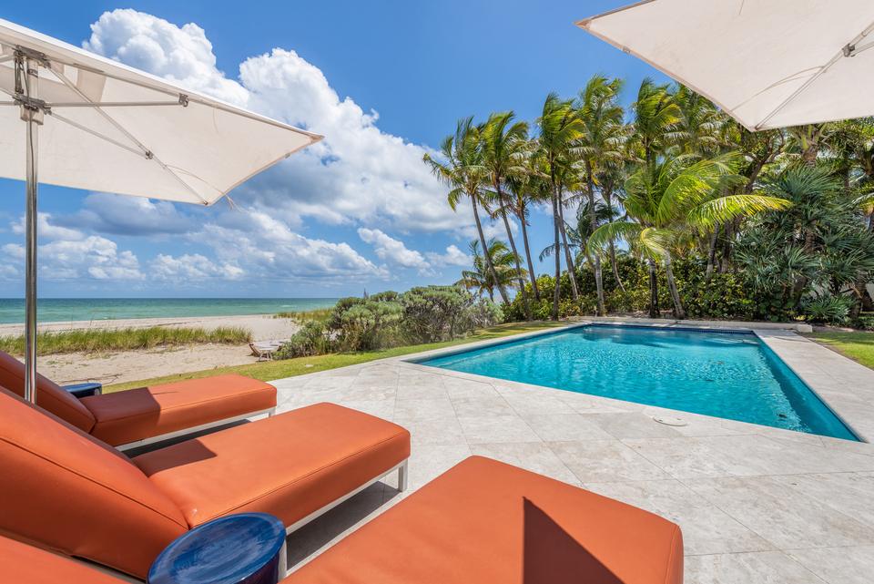 Poolside loungers under parasols facing the sea, Villa Ocean, Miami