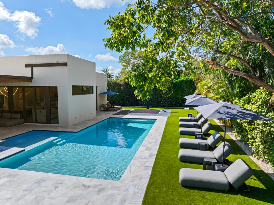 Pool, sun loungers and the modern white house on a sunny day, Villa Meimon, North Miami Beach