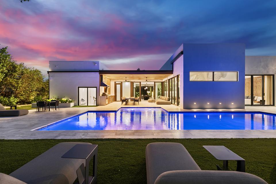 Pool and glass-walled house at dusk, Villa Meimon, North Miami Beach