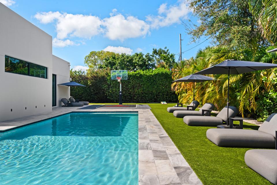 Pool along the house with loungers on the lawn, Villa Meimon, North Miami Beach