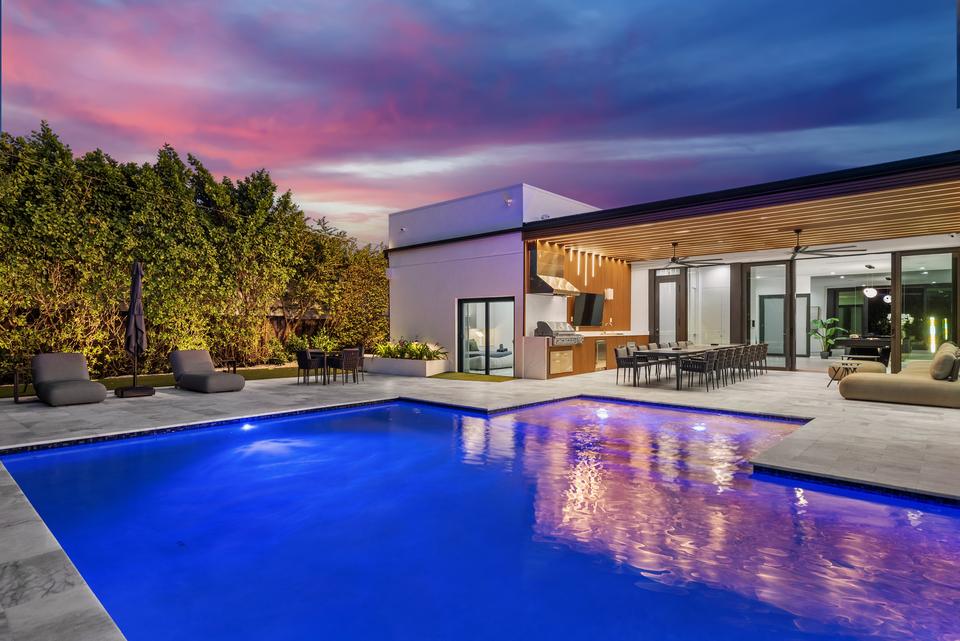 Pool and covered terrace lit at dusk, Villa Meimon, North Miami Beach