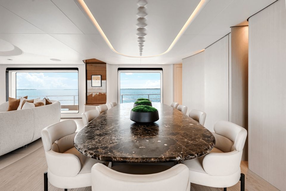 Dining table set for a family inside the 118 ft Azimut yacht, sea views through the windows