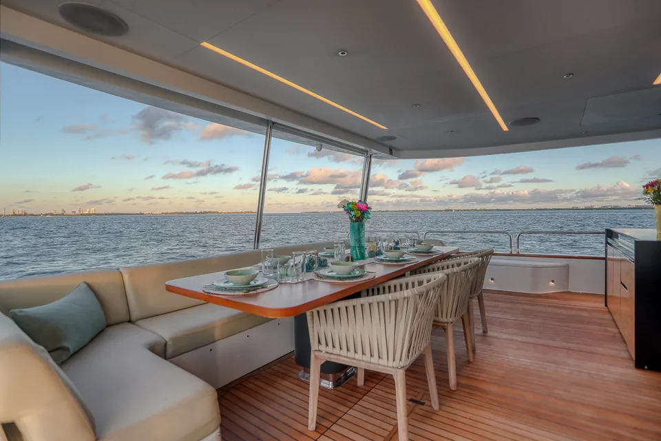 Dining table set on the deck of the Sirena 88 yacht with the sea behind