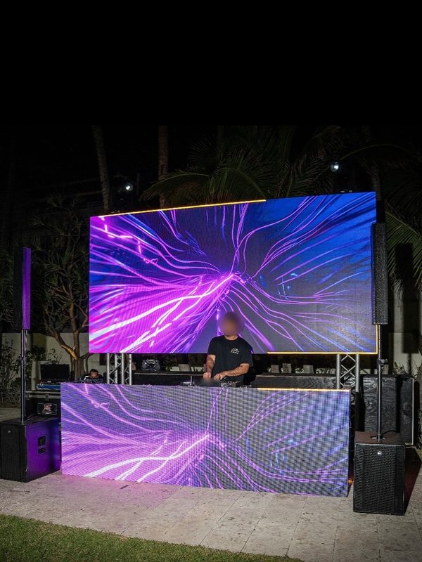 DJ booth with an LED screen on a lawn at night