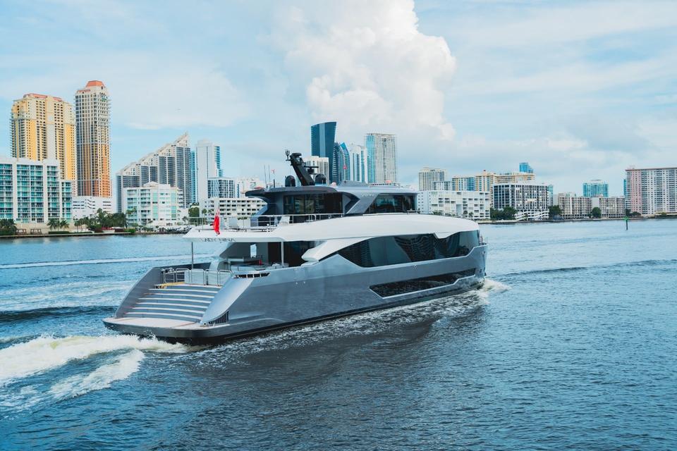 Motor yacht cruising past waterfront high-rises