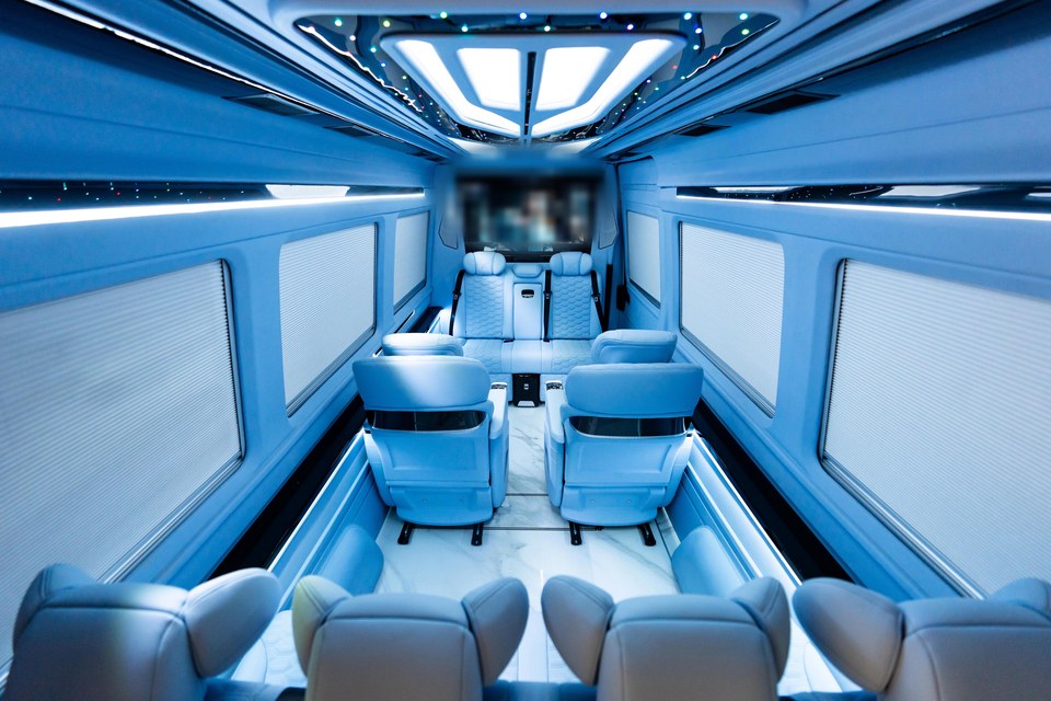 Luxury Sprinter van interior with quilted leather seats, marble floor and blue LED lighting