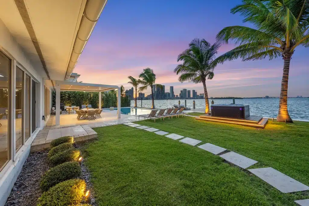 Garden lawn and terrace along the water at sunset, Villa Venetian, Venetian Islands, Miami Beach