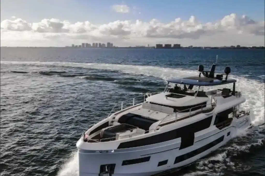 Aerial view of a luxury yacht leaving a white wake on open water near Miami
