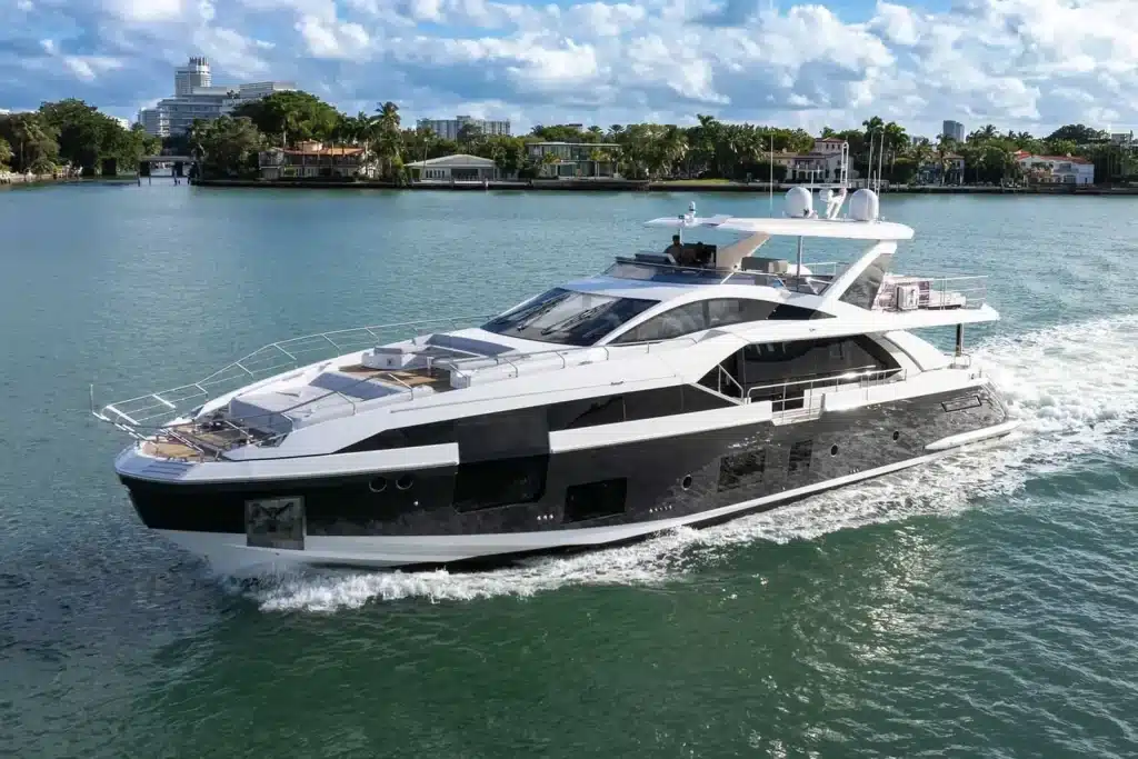 Luxury motor yacht cruising a calm Miami bay past waterfront homes and trees