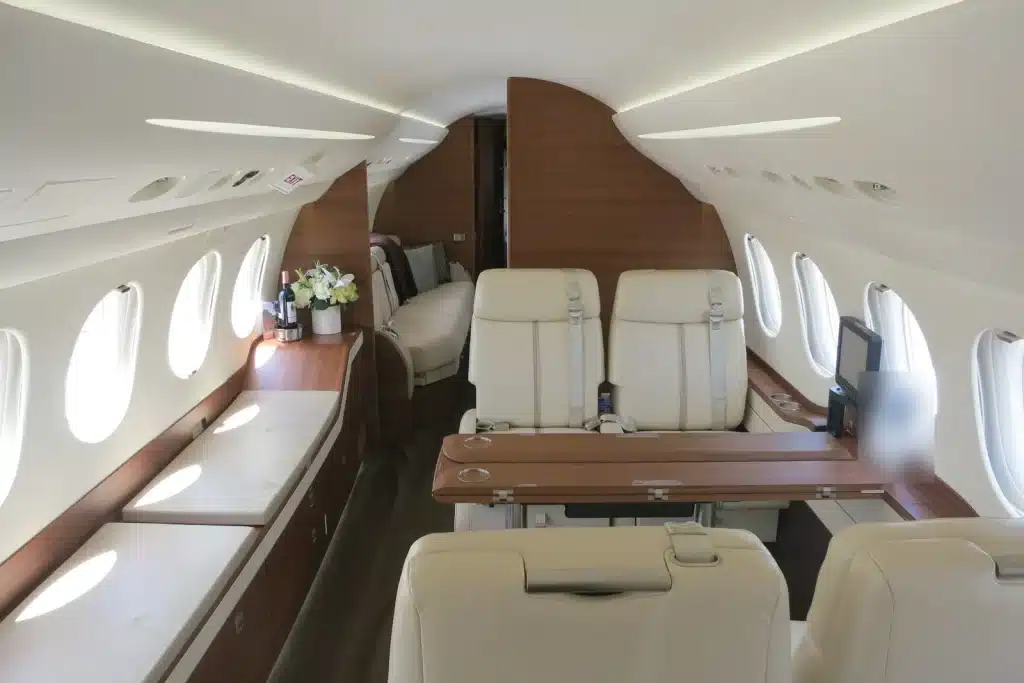 Private jet cabin with cream leather seats and wood trim