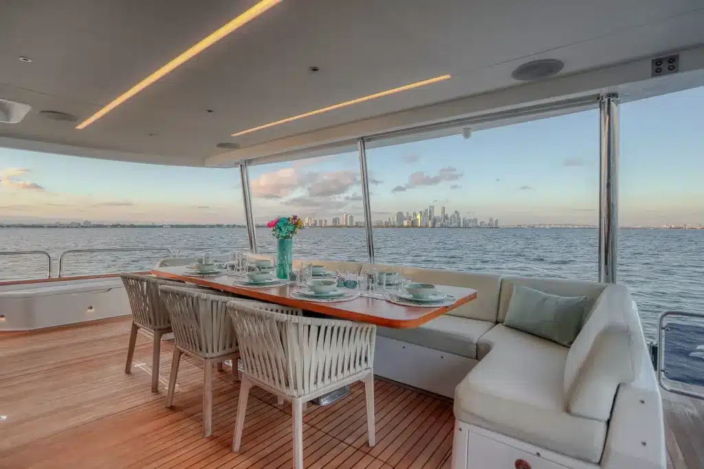 Dining table set for lunch on the deck of the 88 foot Sirena yacht, Miami skyline across Biscayne Bay